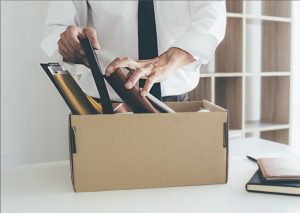 employee packing up desk - termination concept