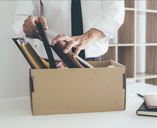 employee packing up desk - termination concept