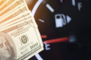 Dollar bank money coming from car fuel mileage dashboard concept closed on financial background