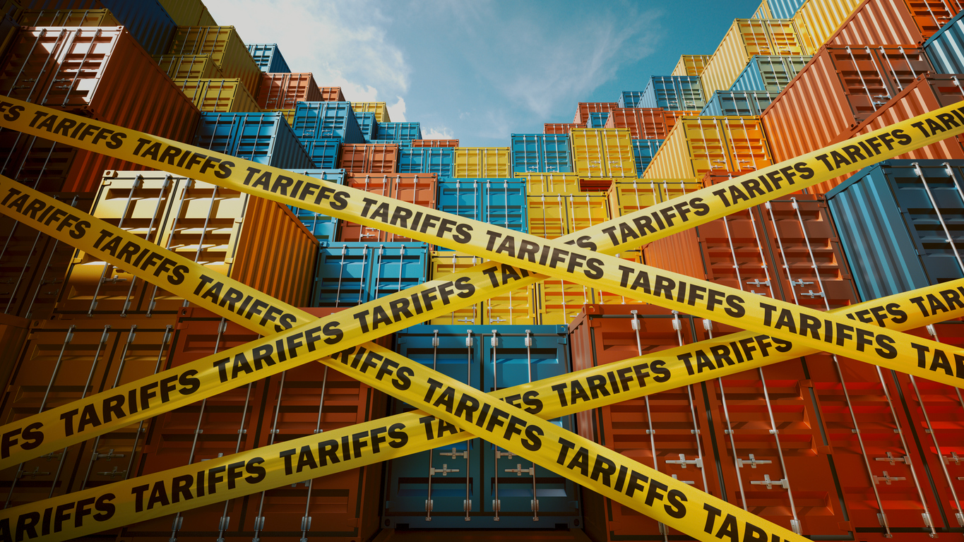 A stack of colorful shipping containers restricted by yellow tape labeled tariffs. Represents global trade challenges, import-export restrictions, and economic impacts of international tariff policies.