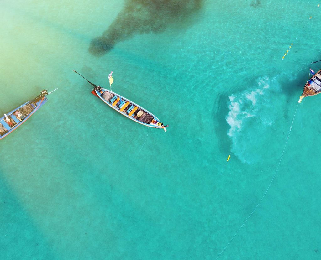 Aerial view of long tail boats along a tropical beach, Thailand.