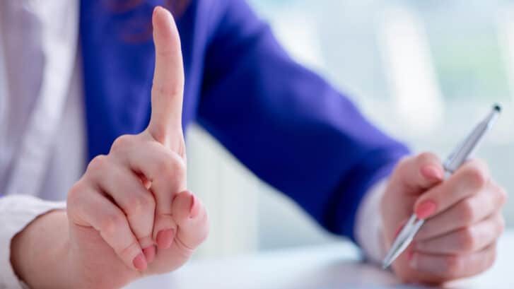 Businesswoman,Writing,Notes,At,Desk