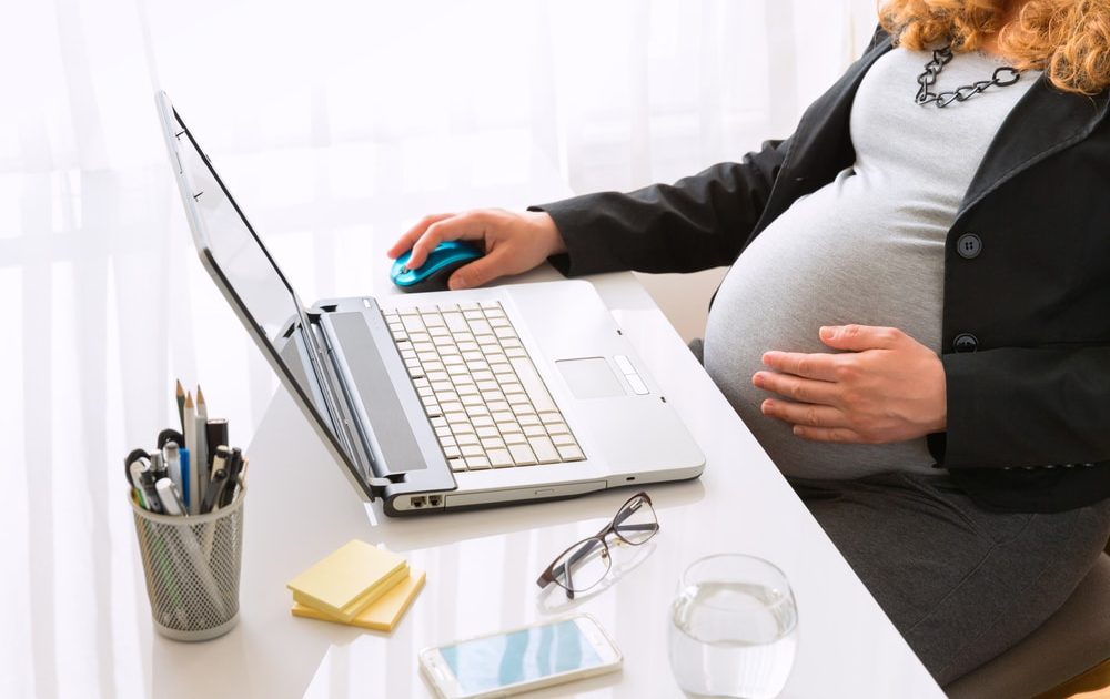 Young,Pregnant,Business,Woman,Sitting,At,The,Desk,And,Working