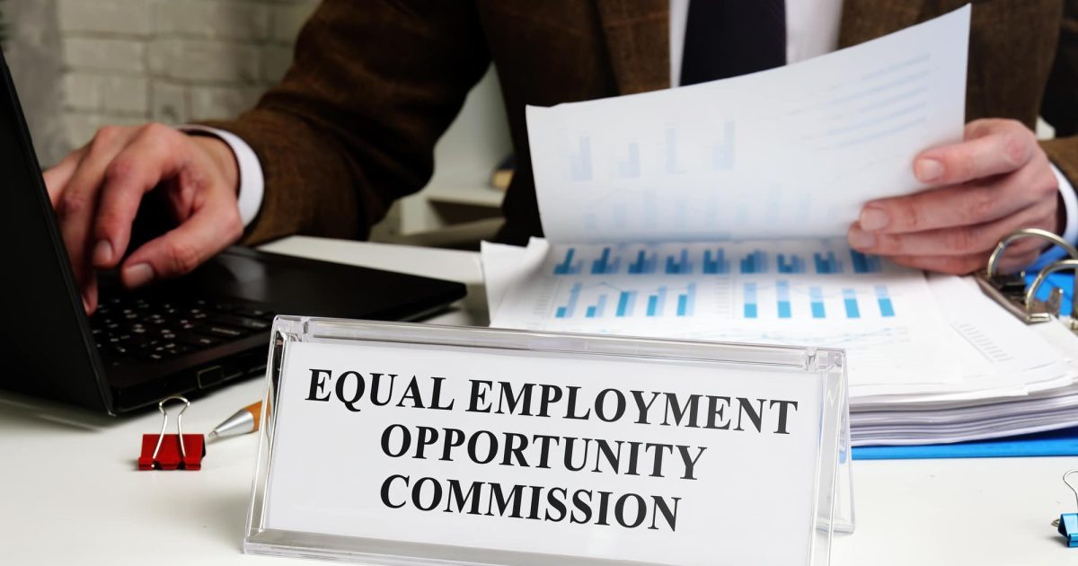 A man works at a table with a tablet Equal Employment Opportunity Commission EEOC.