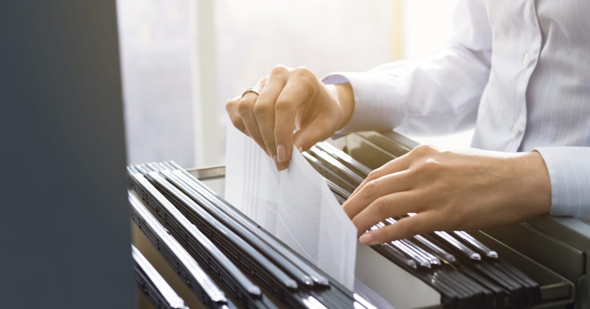 Office clerk searching files in the filing cabinet